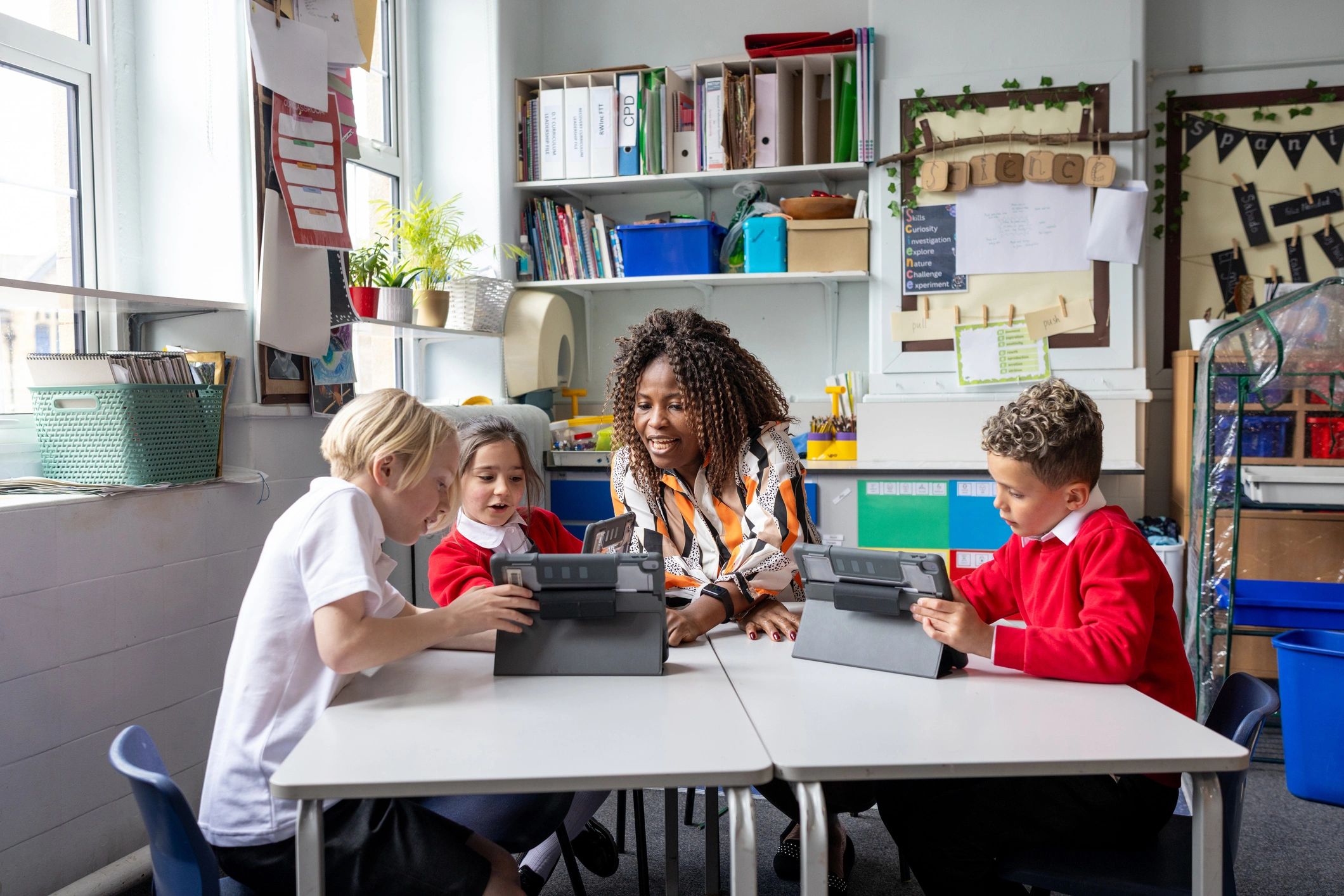 Teacher and students using digital tablets together