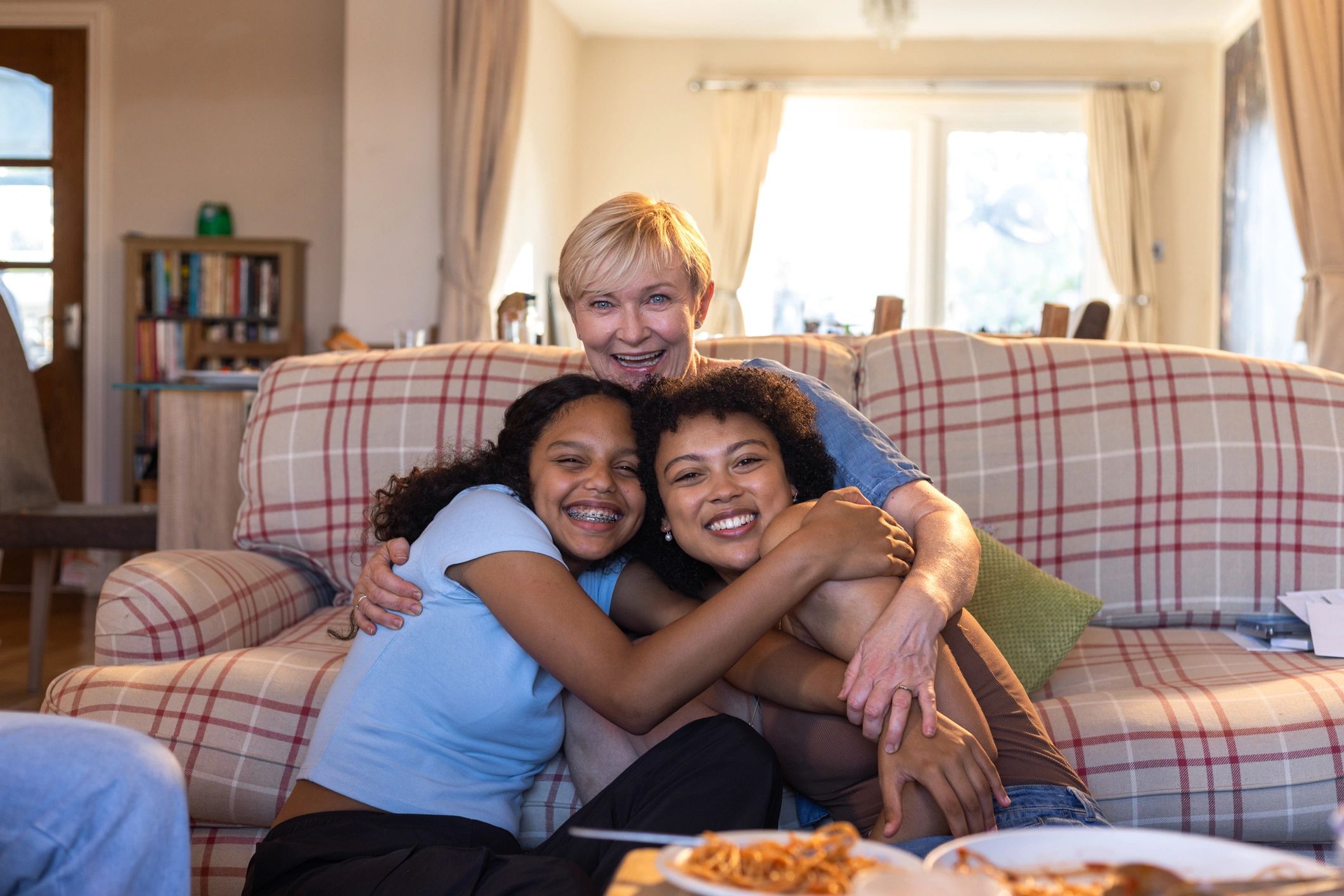 Mother and daughters sitting together and smiling
